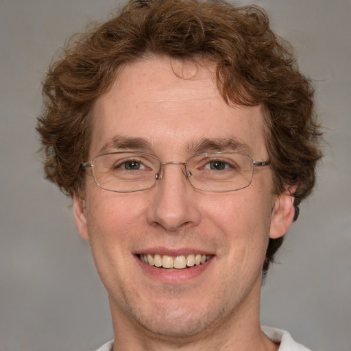 Joyful white adult male with short  brown hair and grey eyes