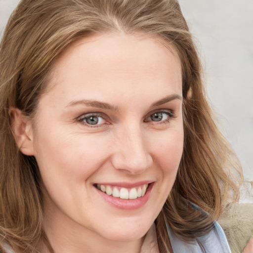 Joyful white young-adult female with long  brown hair and blue eyes