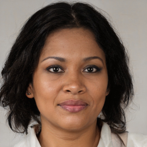 Joyful black adult female with medium  brown hair and brown eyes
