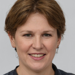 Joyful white adult female with medium  brown hair and grey eyes