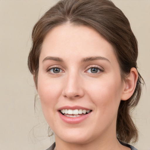 Joyful white young-adult female with medium  brown hair and grey eyes