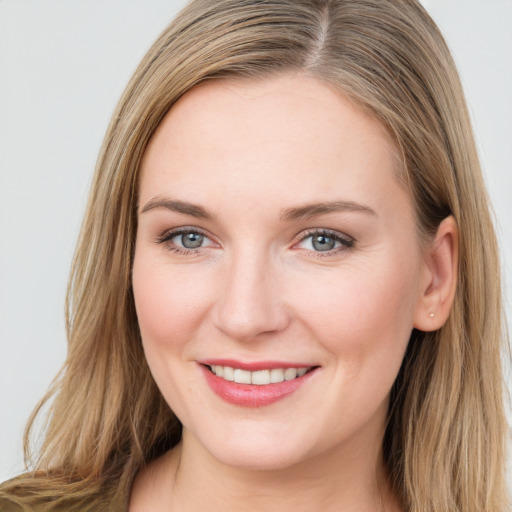 Joyful white young-adult female with long  brown hair and grey eyes