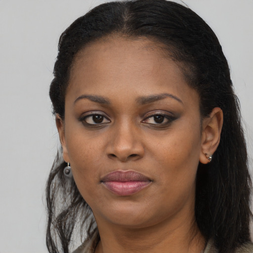Joyful black young-adult female with long  black hair and brown eyes