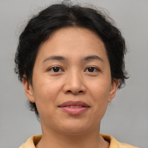 Joyful asian adult female with medium  brown hair and brown eyes