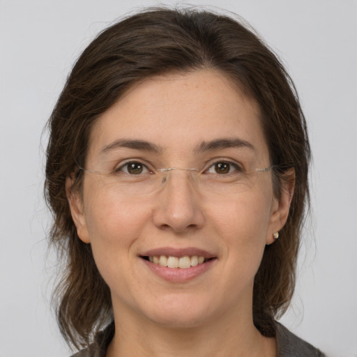 Joyful white adult female with medium  brown hair and grey eyes