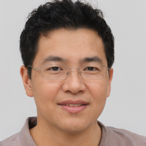 Joyful asian adult male with short  brown hair and brown eyes