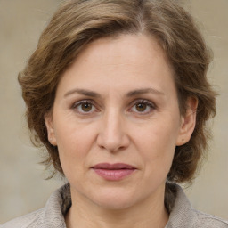 Joyful white adult female with medium  brown hair and grey eyes