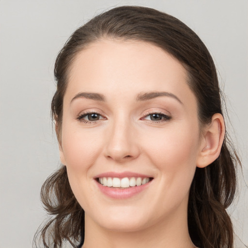 Joyful white young-adult female with long  brown hair and brown eyes