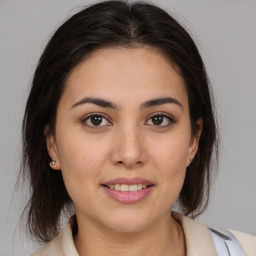 Joyful latino young-adult female with medium  brown hair and brown eyes