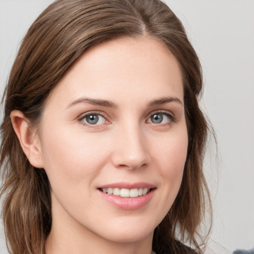 Joyful white young-adult female with medium  brown hair and grey eyes