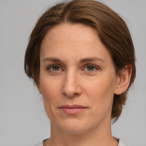 Joyful white adult female with medium  brown hair and grey eyes