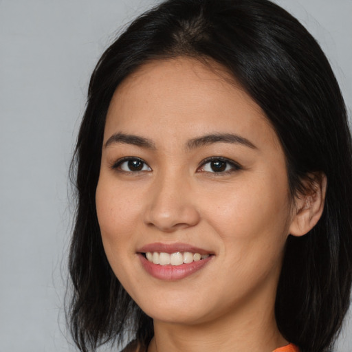 Joyful asian young-adult female with long  black hair and brown eyes