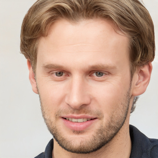 Joyful white young-adult male with short  brown hair and grey eyes