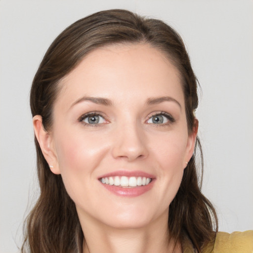 Joyful white young-adult female with long  brown hair and grey eyes