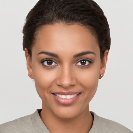 Joyful latino young-adult female with short  brown hair and brown eyes