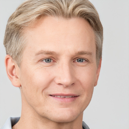 Joyful white adult male with short  brown hair and blue eyes