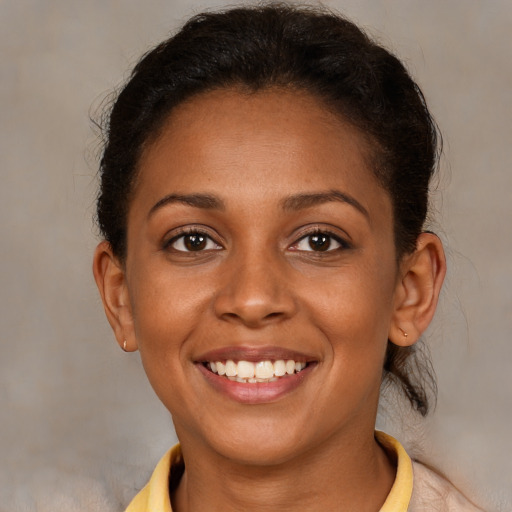 Joyful black young-adult female with short  brown hair and brown eyes