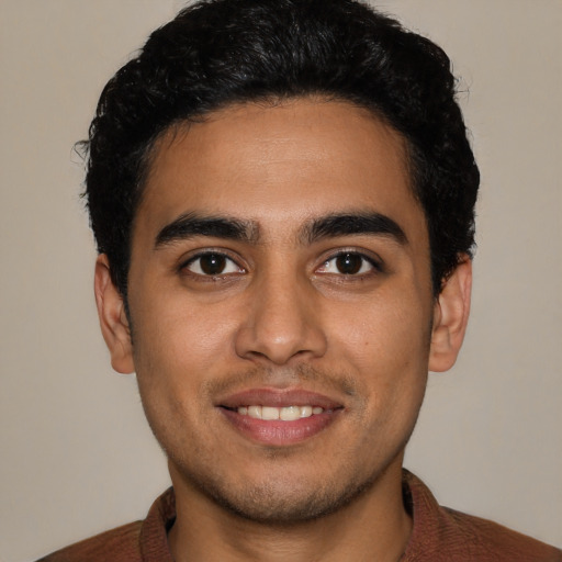 Joyful latino young-adult male with short  brown hair and brown eyes