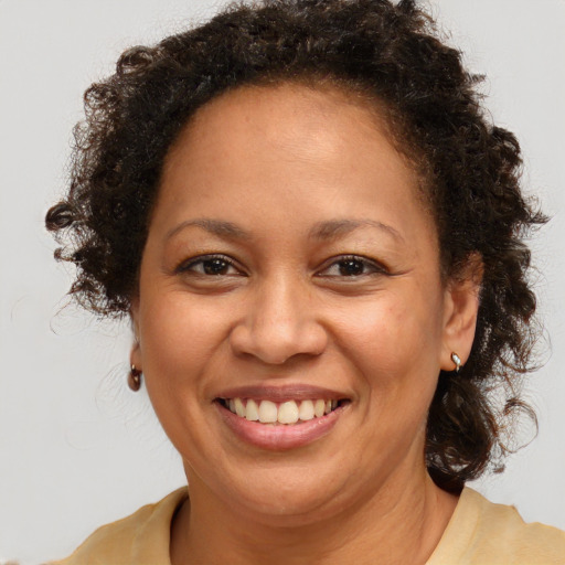 Joyful black adult female with medium  brown hair and brown eyes