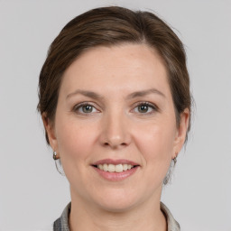 Joyful white young-adult female with medium  brown hair and grey eyes