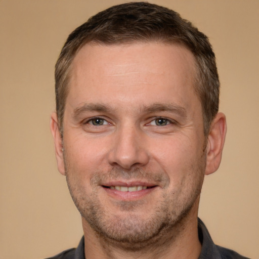 Joyful white adult male with short  brown hair and brown eyes