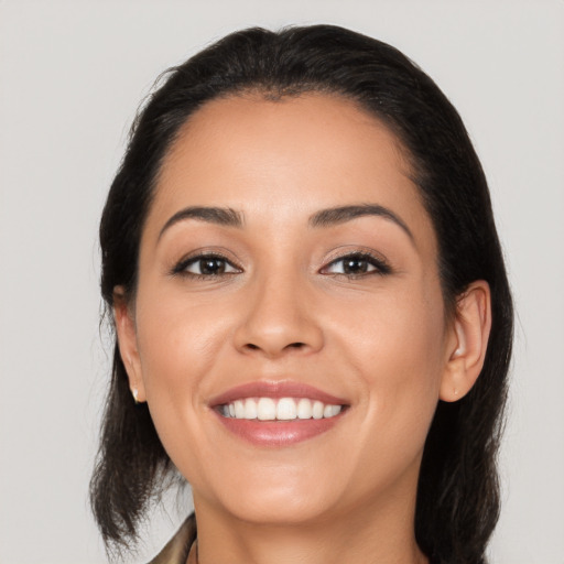 Joyful latino young-adult female with medium  brown hair and brown eyes