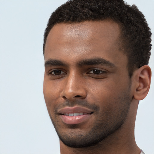 Joyful black young-adult male with short  brown hair and brown eyes