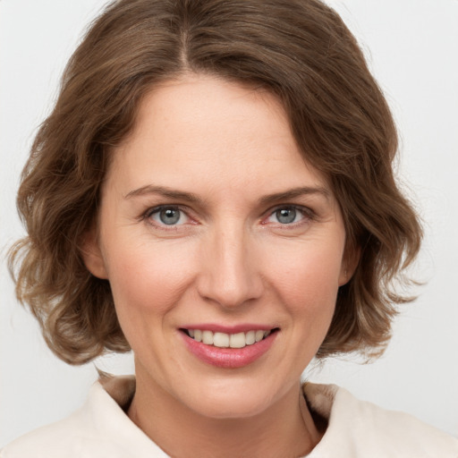 Joyful white adult female with medium  brown hair and grey eyes