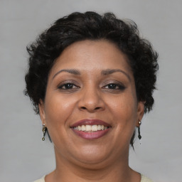 Joyful latino adult female with short  brown hair and brown eyes
