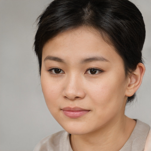 Joyful asian young-adult female with medium  brown hair and brown eyes