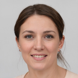 Joyful white young-adult female with medium  brown hair and grey eyes