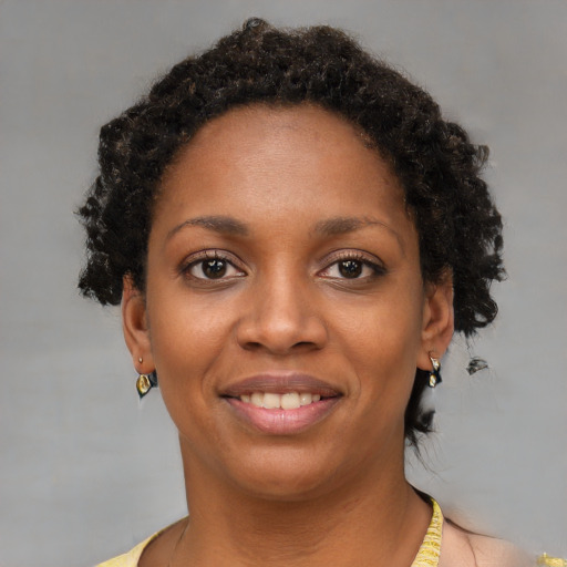 Joyful black young-adult female with short  brown hair and brown eyes
