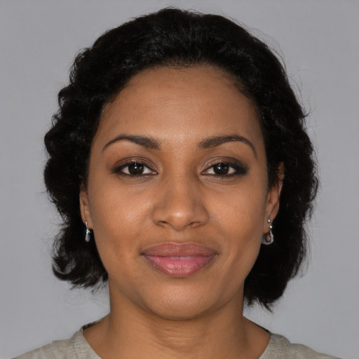 Joyful black adult female with medium  black hair and brown eyes