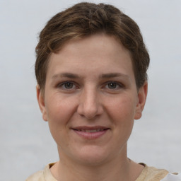 Joyful white young-adult female with short  brown hair and grey eyes