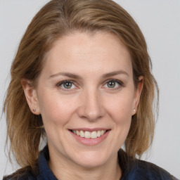 Joyful white adult female with medium  brown hair and grey eyes