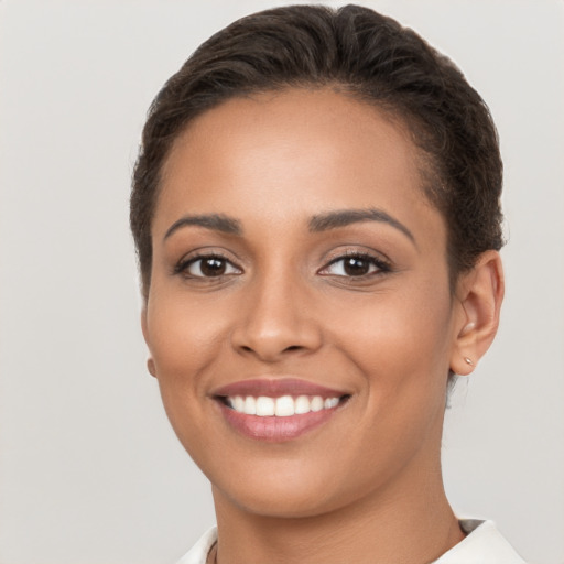 Joyful latino young-adult female with short  brown hair and brown eyes