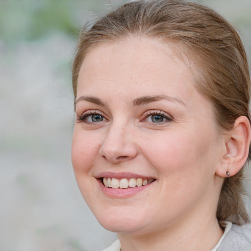 Joyful white young-adult female with medium  brown hair and blue eyes