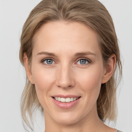 Joyful white young-adult female with medium  brown hair and grey eyes