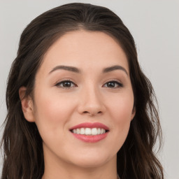 Joyful white young-adult female with long  brown hair and brown eyes