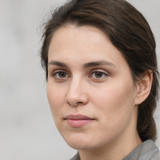 Joyful white young-adult female with medium  brown hair and grey eyes