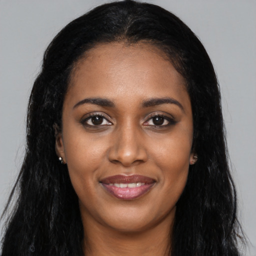 Joyful black young-adult female with long  black hair and brown eyes