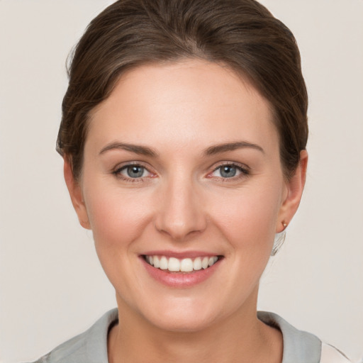 Joyful white young-adult female with short  brown hair and grey eyes