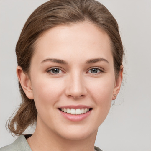 Joyful white young-adult female with medium  brown hair and grey eyes