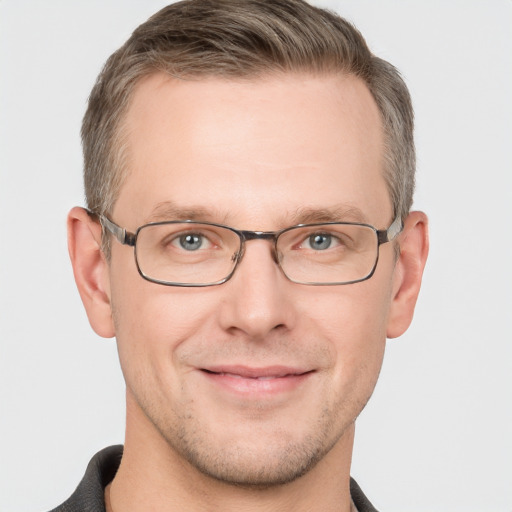 Joyful white adult male with short  brown hair and grey eyes