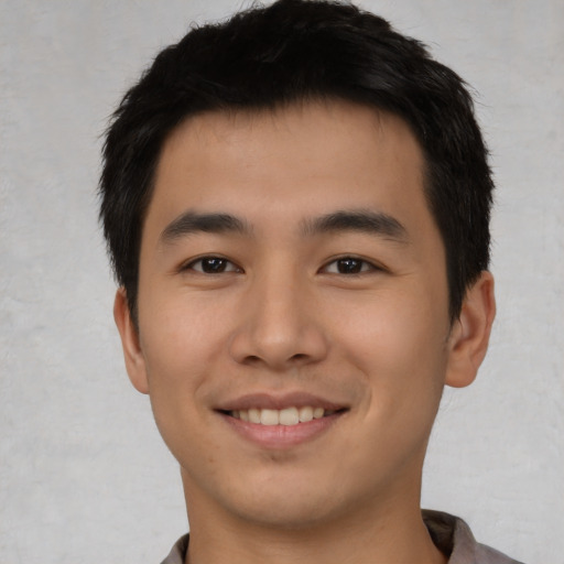 Joyful asian young-adult male with short  black hair and brown eyes