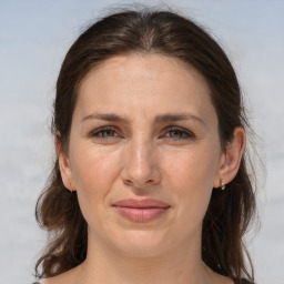 Joyful white adult female with long  brown hair and brown eyes