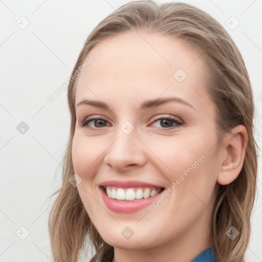 Joyful white young-adult female with long  brown hair and blue eyes