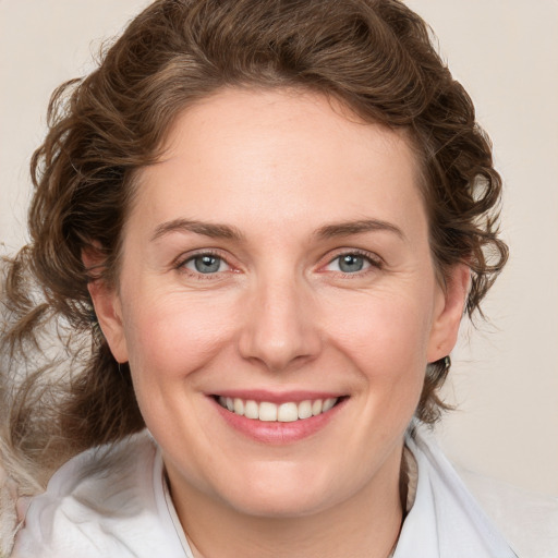 Joyful white adult female with medium  brown hair and blue eyes