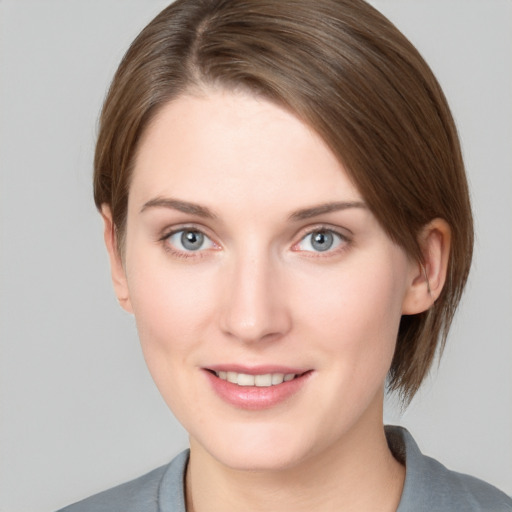 Joyful white young-adult female with medium  brown hair and grey eyes