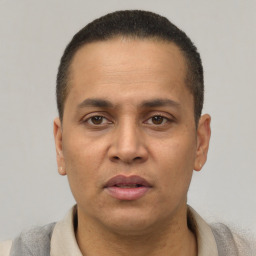 Joyful latino adult male with short  black hair and brown eyes
